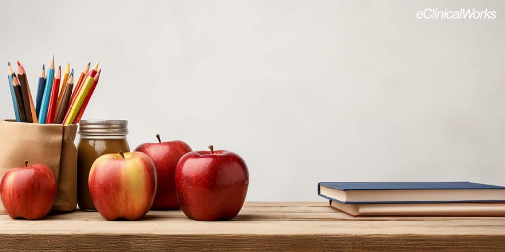 Apples, colored pencils and books on top of a desk