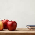 Apples, colored pencils and books on top of a desk