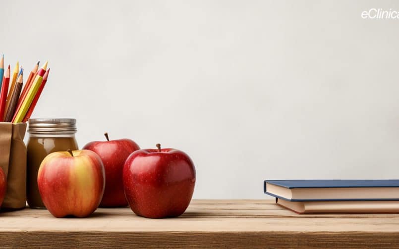 Apples, colored pencils and books on top of a desk