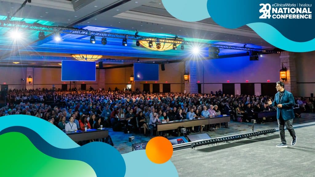 Man on stage overlooking a full crowd at a healthcare conference