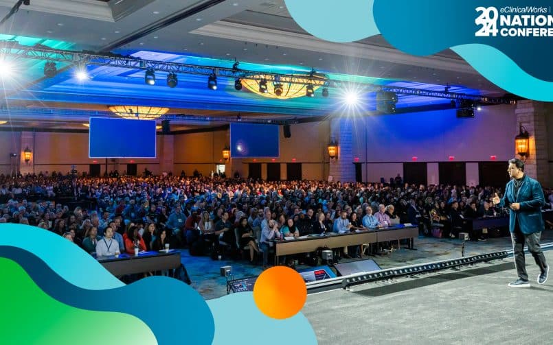 Man on stage overlooking a full crowd at a healthcare conference